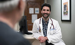 Brian Hess talks with a patient in his office